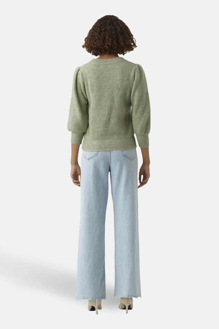 Groene trui met ronde hals van VERO MODA®, met korte pofmouwen en een ribgebreide textuur, gedragen met een lichtblauwe jeans met wijde pijpen.
