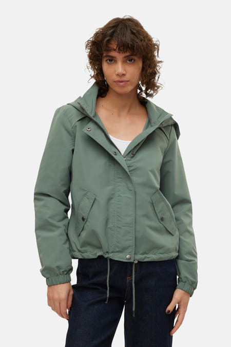 Korte groene jas van VERO MODA, met capuchon, zakken met knoopsluiting en trekkoord aan de onderkant.
