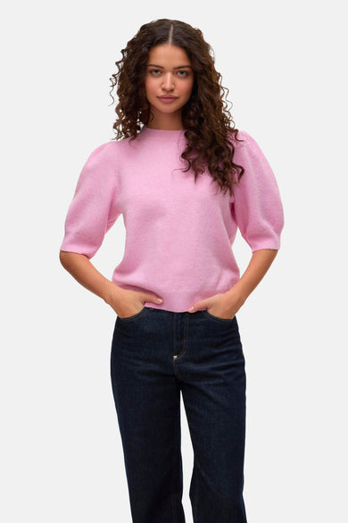 Roze trui met ronde hals van VERO MODA, met pofmouwen en donkere jeans.
