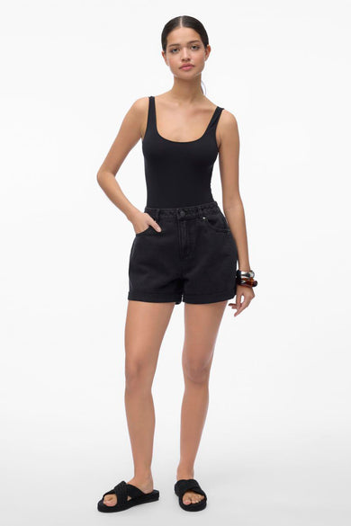 Zwarte short van VERO MODA, met hoge taille, omgeslagen zoom en gedragen met een zwarte tanktop en sandalen.
