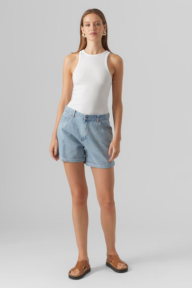 Lichtblauwe denim short van Vero Moda, gedragen met een witte tanktop en bruine sandalen.