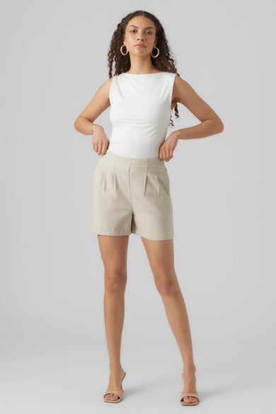 Beige short van VERO MODA®, geplooid aan de voorkant, gedragen met een witte top en nude hakken.