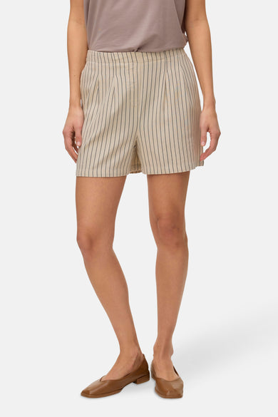 Beige gestreepte short van Vero Moda, met verticale zwarte strepen en bruine schoenen.