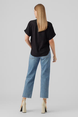 Chemisier noir à manches courtes de VERO MODA, vu de dos, associé à un jean et des talons beiges.