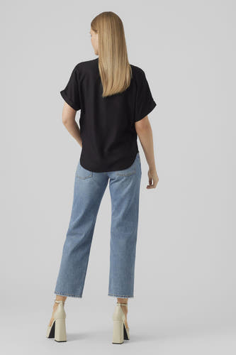 Chemisier noir à manches courtes de VERO MODA, vu de dos, combiné avec un jean bleu et des talons beiges.