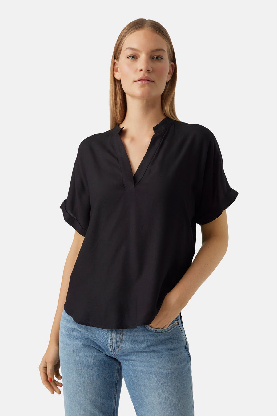 Zwarte blouse met korte mouwen van VERO MODA, met een V-hals en gedragen met een blauwe jeans.
