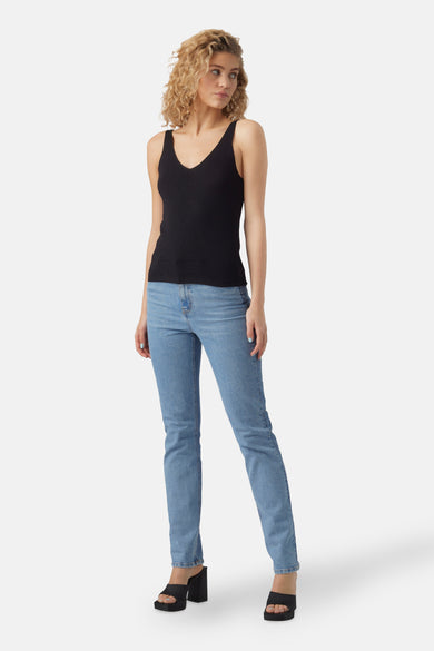 Zwarte top met spaghettibandjes van VERO MODA, geribbelde textuur, gecombineerd met jeans en open schoenen met hak.
