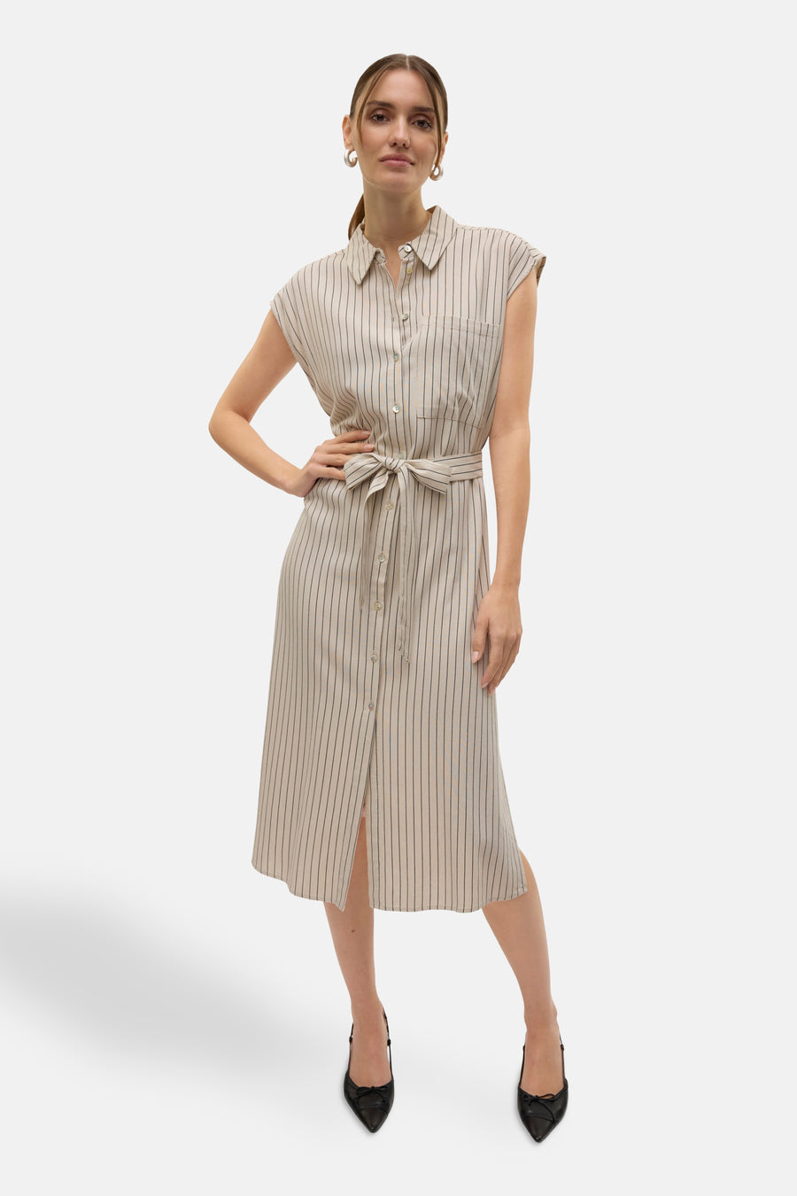 Robe beige sans manches de VERO MODA, avec des rayures verticales, une ceinture et des chaussures noires.