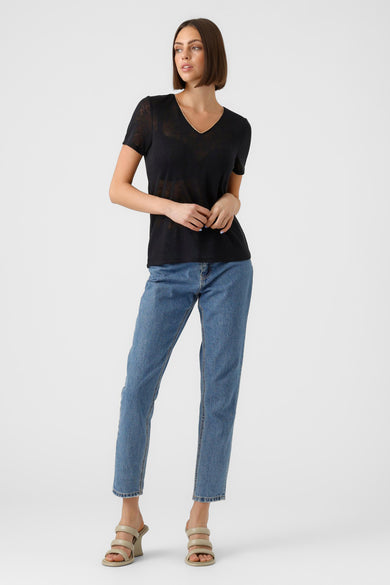 Zwart T-shirt met korte mouwen van VERO MODA, met een V-hals en gedragen met blauwe jeans en sleehakken.
