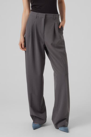 Grijze wijde broek van VERO MODA® met plooien en hoge taille, gedragen met zwarte top en blauwe schoenen, front view