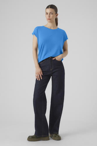 T-shirt bleu à manches courtes de VERO MODA, porté avec des jeans larges et des chaussures vertes.