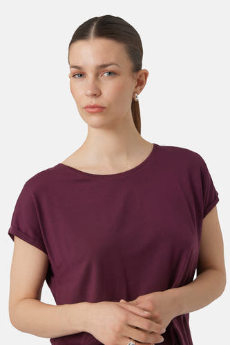 Paars T-shirt met korte mouwen van Vero Moda, met omgeslagen mouwen, gedragen door een vrouw met zilveren oorbellen.
