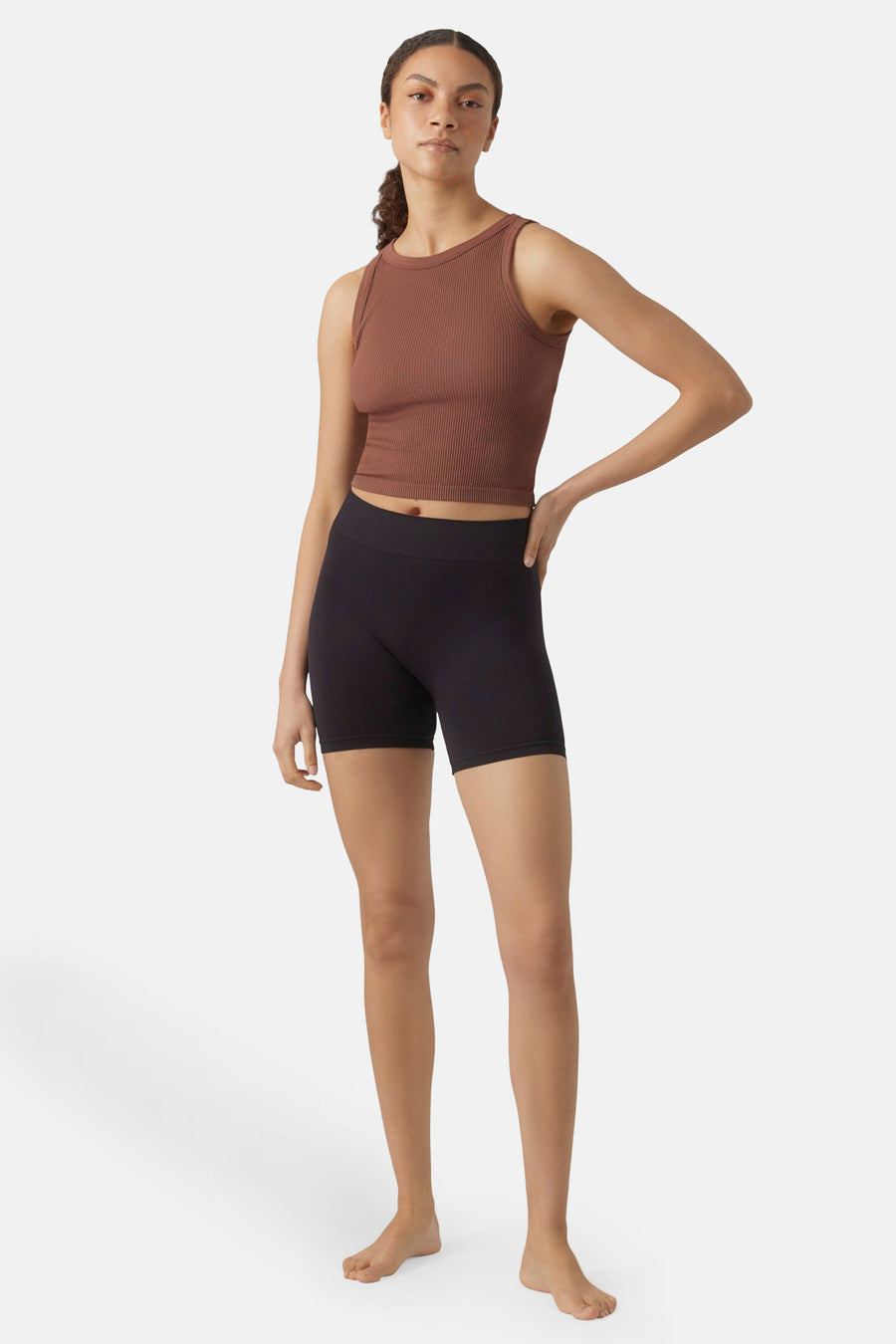 Zwarte shorty boxers van VERO MODA, gecombineerd met een bruine top en blootsvoets staand.