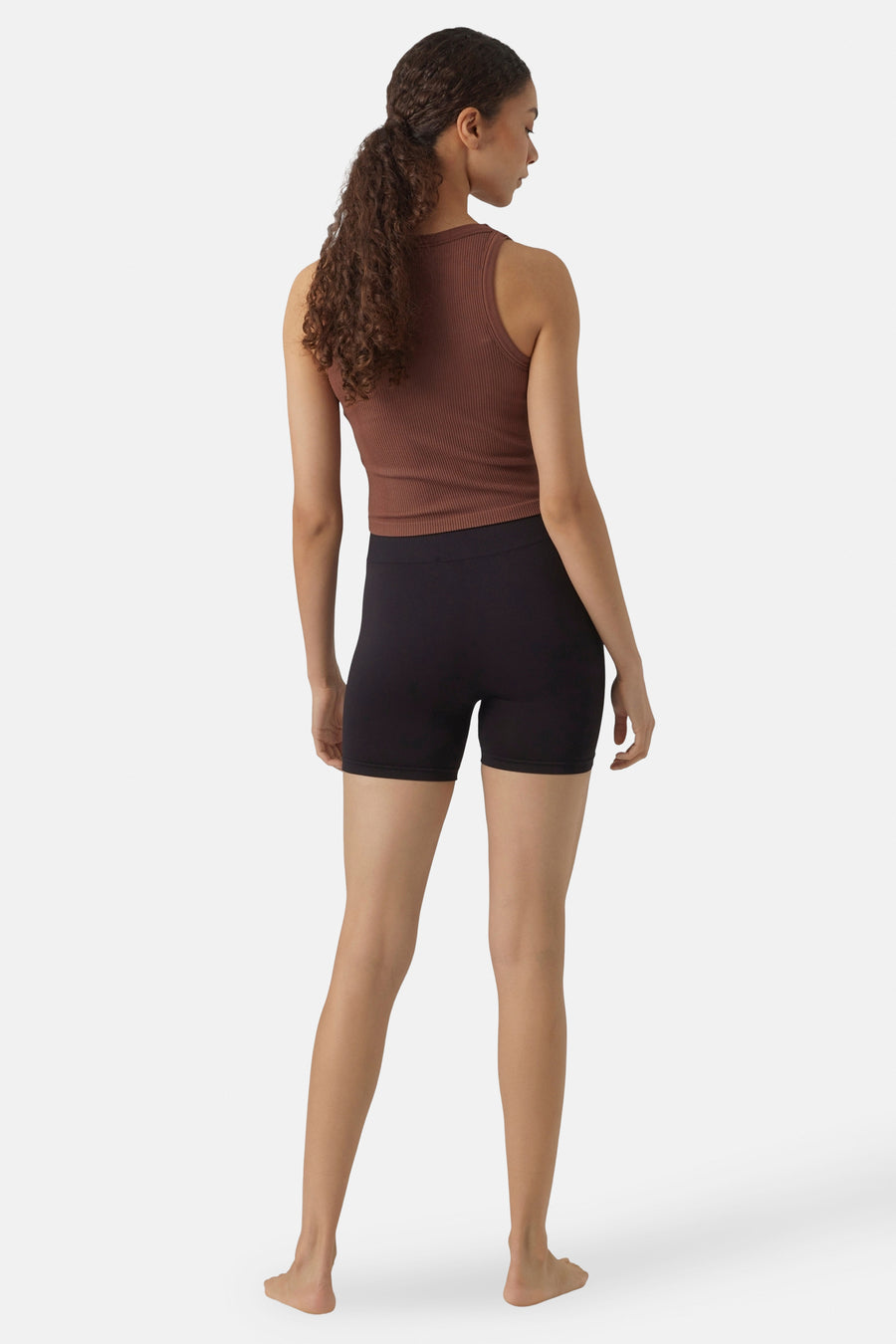 Shorty noir de Vero Moda, avec une coupe ajustée, porté avec un haut marron, vu de derrière.