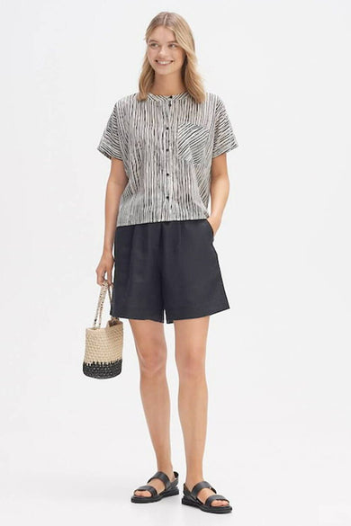 Wit kortemouwen hemd met verticale zwarte strepen van OPUS, met borstzak met diagonale strepen, gedragen met zwarte shorts en sandalen.