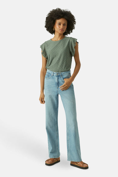 T-shirt vert avec manches courtes de Vero Moda, doté de détails brodés et porté avec des jeans bleus.