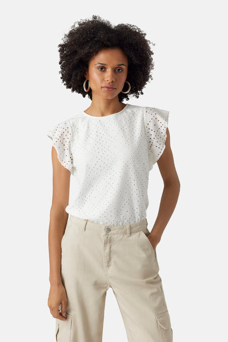 Witte T-shirt met korte mouwen van VERO MODA®, met broderie details en ronde hals, gecombineerd met een beige broek.

