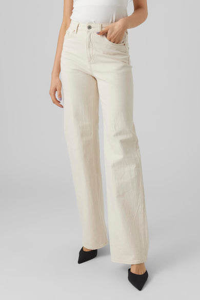 Jean en denim blanc cassé large de Vero Moda, avec des jambes larges et portés avec des chaussures noires.