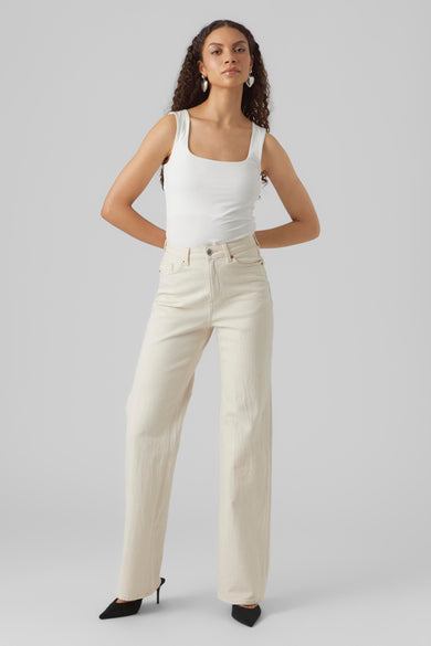 Jean en denim blanc cassé large de VERO MODA, portés avec un t-shirt blanc et des baskets noires.