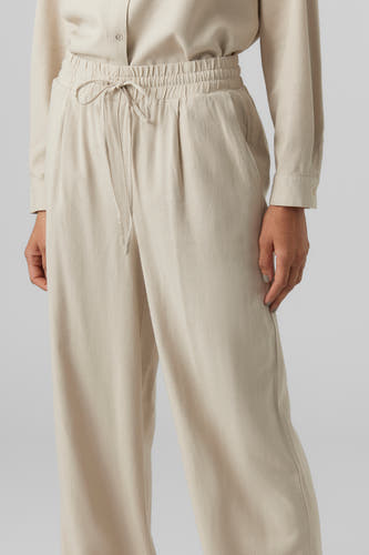 Pantalon beige de VERO MODA avec cordon et larges pinces, faisant partie d'un ensemble coordonné.