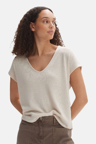 Ecru blouse met korte mouwen van OPUS, met een V-hals en gedragen met een bruine broek.
