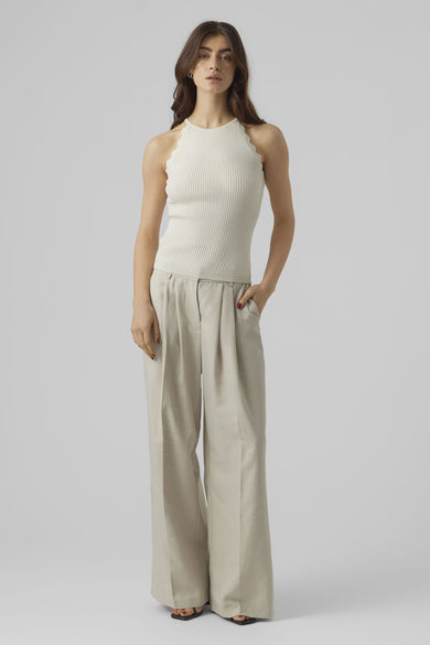 Ecru pull met ronde hals van VERO MODA, gedragen met plooibroek en zwarte sandalen.