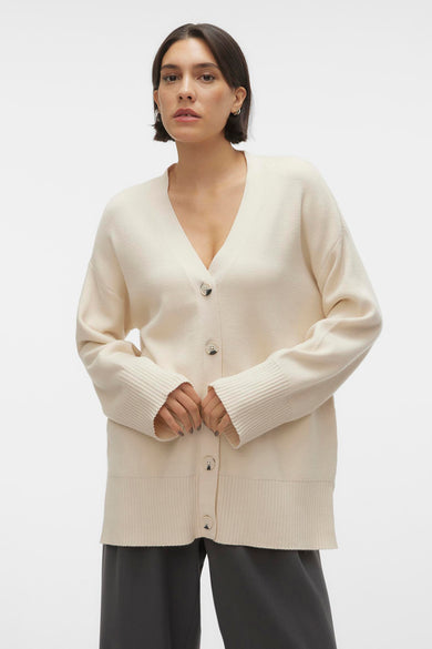Gilet beige de VERO MODA®, porté avec des pantalons gris et des chaussures noires.