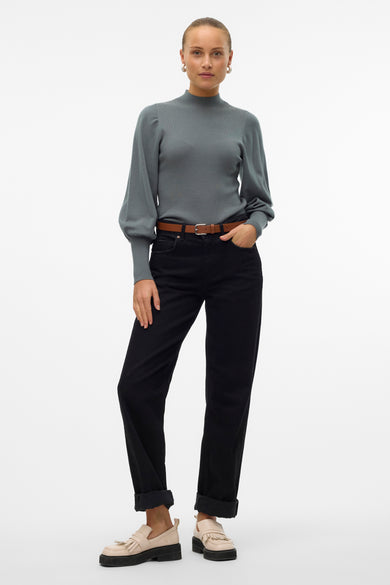 T-shirt vert avec col montant de VERO MODA, manches longues, associé à une ceinture brune et des jeans noirs plissés.