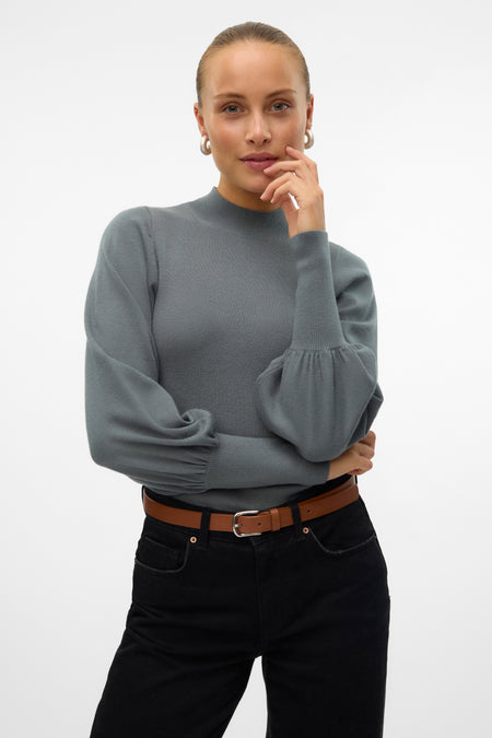 Veste verte VERO MODA, avec des manches ballon longues, associée à un pantalon noir et une ceinture marron.
