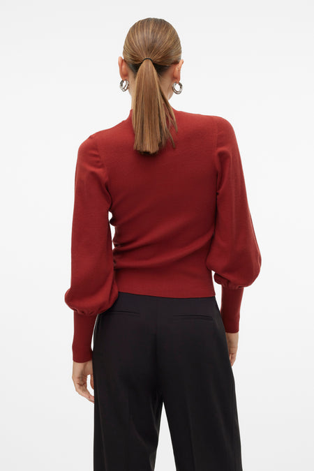 Pull marron avec col montant de VERO MODA, vu de derrière, avec des manches bouffantes et porté avec un pantalon noir.