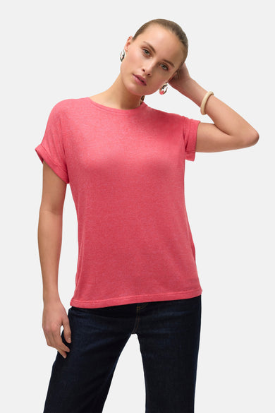Roze T-shirt met korte mouwen van VERO MODA®, gedragen met donkere jeans en zilverkleurige oorbellen.
