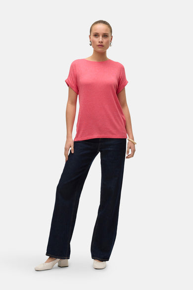 Roze T-shirt met korte mouwen van VERO MODA, met losse pasvorm gecombineerd met donkerblauwe jeans en witte hakken.