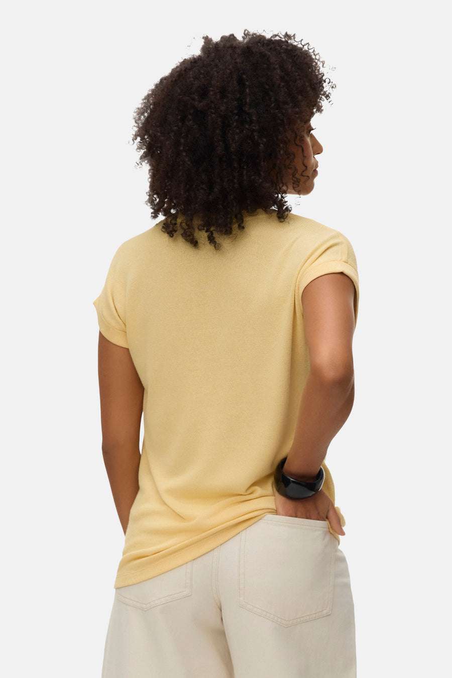 Geel T-shirt met korte mouwen van VERO MODA®, achterkant gezien met een hand in de broekzak.