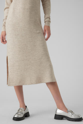 Beige jurk met lange mouwen van VERO MODA, met split en ondoorzichtige zilverkleurige schoenen.
