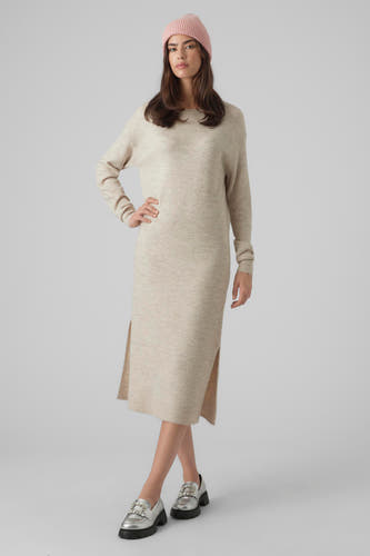 Beige kleedje met lange mouwen van VERO MODA, met zijsplit en een roze muts en zilverkleurige schoenen.
