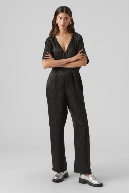 Zwarte jumpsuit van VERO MODA met een glanzende textuur en een V-hals.
