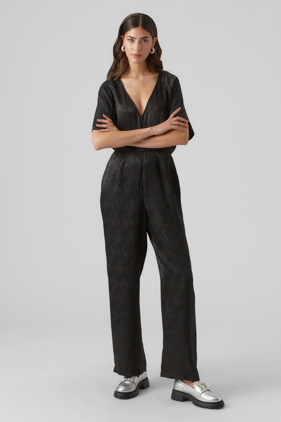 Combinaison noire de VERO MODA avec une texture brillante et un col V.