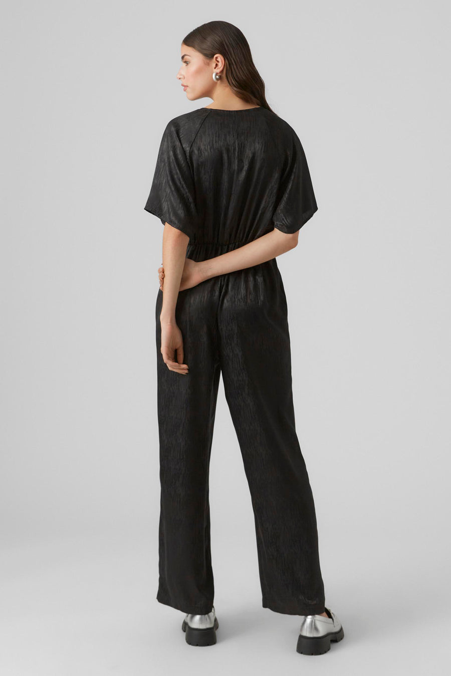 Short jumpsuit V VERO MODA® with short sleeves, elastic waistband and wide legs, seen from behind.
