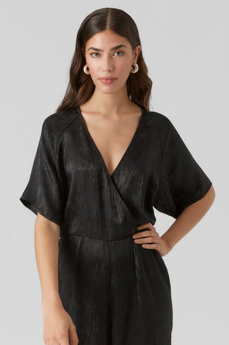 Combinaison noire de VERO MODA, avec une texture tissée et un profond col en V.
