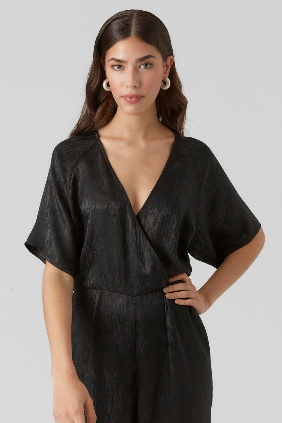 Combinaison noire de VERO MODA, avec une texture tissée et un profond col en V.