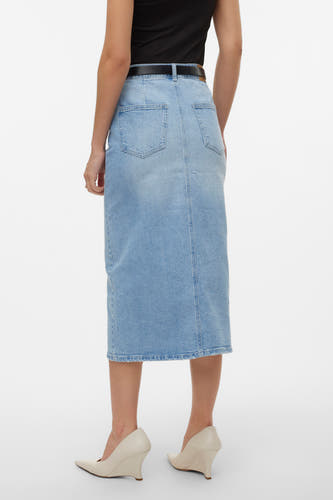 Jupe en denim bleu clair de VERO MODA, avec deux poches arrière et une ceinture noire, portée avec des escarpins à talon compensé couleur crème.