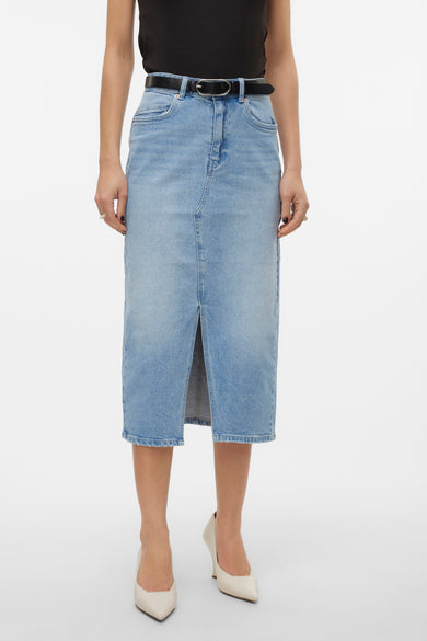 Lichtblauwe denim rok van VERO MODA®, met een split aan de voorkant en beige schoenen.
