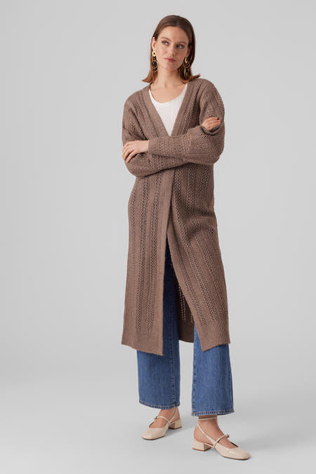 Bruin gebreid vest van Vero Moda, met lange mouwen, gedragen over een wit shirt en blauwe jeans.