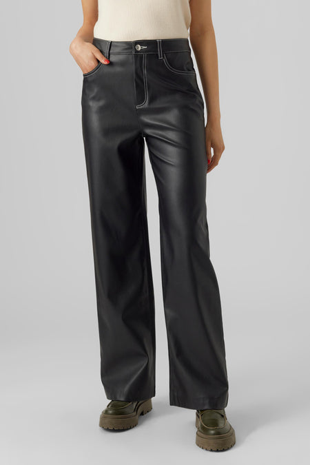 Zwarte cargobroek van VERO MODA®, met witte stiksels, losse pasvorm en groene schoenen.
