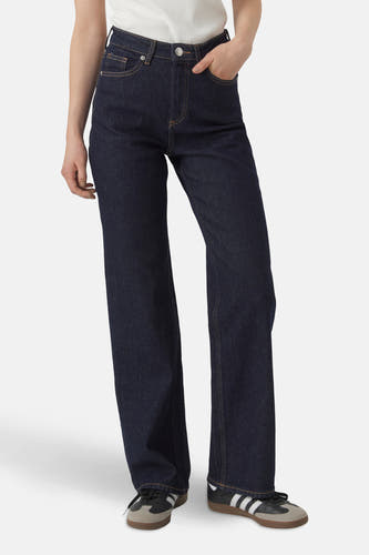 Jean bleu marine, large de VERO MODA, avec des surures dorées et associé à des baskets.