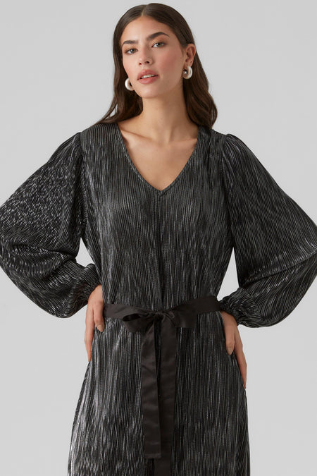 Lange zwarte kleedje van VERO MODA, met plooien, lange mouwen en een zwarte strikceintuur.
