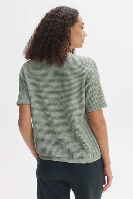 Groen T-shirt met korte mouwen van OPUS, met wafeltextuur, achterkant, gedragen met donkergroene broek.
