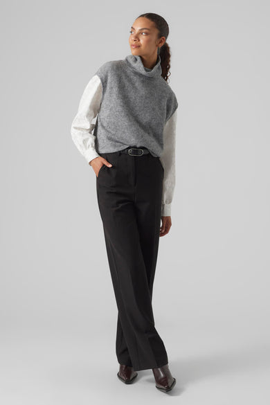 Grijze trui van VERO MODA, gecombineerd met een witte blouse en zwarte pantalon, staand weergegeven.