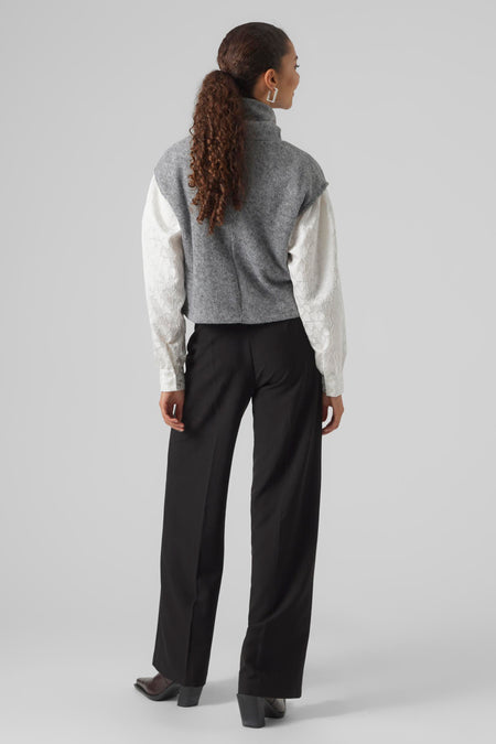 Grijze trui van VERO MODA, met lange mouwen en een witte blouse met hartjesmotief, gezien van achteren.
