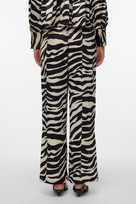 Zwart-wit broek van VERO MODA®, met zebraprint, en wijde pijpen, gezien van achteren.

